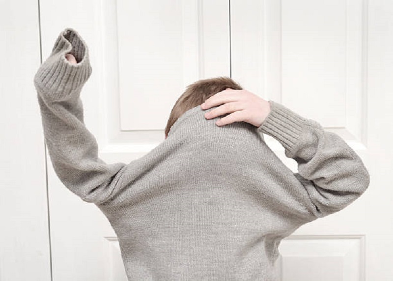 Close up of a young boy getting dressed.